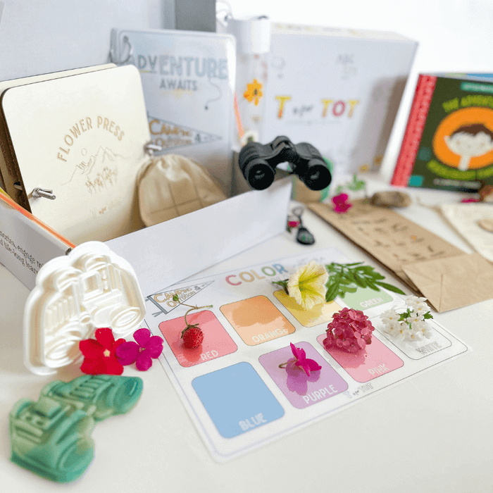 Colorful T is for Tot kit with educational materials, flower press, and creative tools for toddlers' learning experiences.