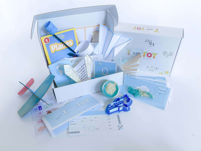 Kids' airplane construction and play kit with airplane playdough cutter, homemade playdough, measuring tape, tens cards, steam and recipe cards, airplane tickets, passport, and pilot license for a fun and educational experience.