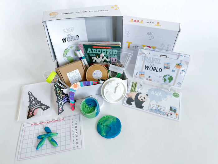 Interactive Around the World play and learn kit for kids. Includes 'Around the World in 80 Days' board book, custom made map, Earth playdough cutter, homemade playdough, Travel the World pack, crafts for each continent, and science experiments for fun educational journeys.