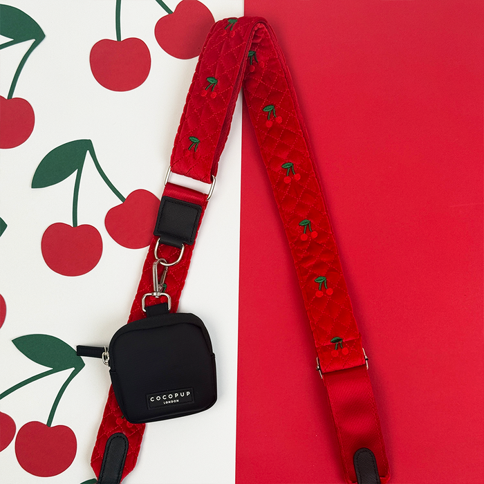 Cherry velvet bag strap from Cocopup London paired with a black pouch, styled for dog walking bags.