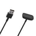 Black Fitbit Charge 5/6/Luxe charger from That Watch Shop, compatible with Fitbit fitness trackers, shown on a white background.