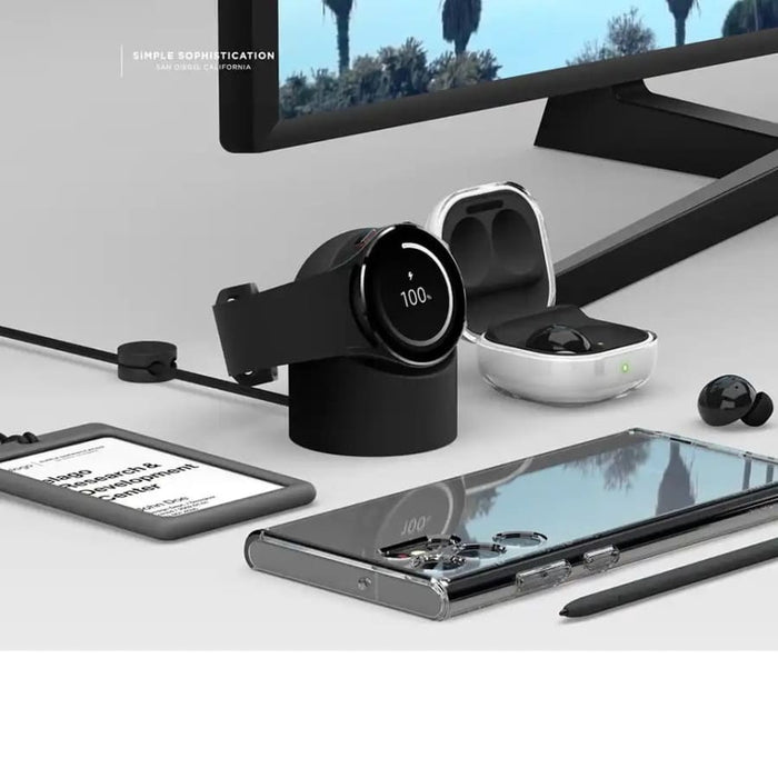 Samsung Watch charging stand on a desk with electronic devices, designed for convenient charging of Samsung smartwatches.