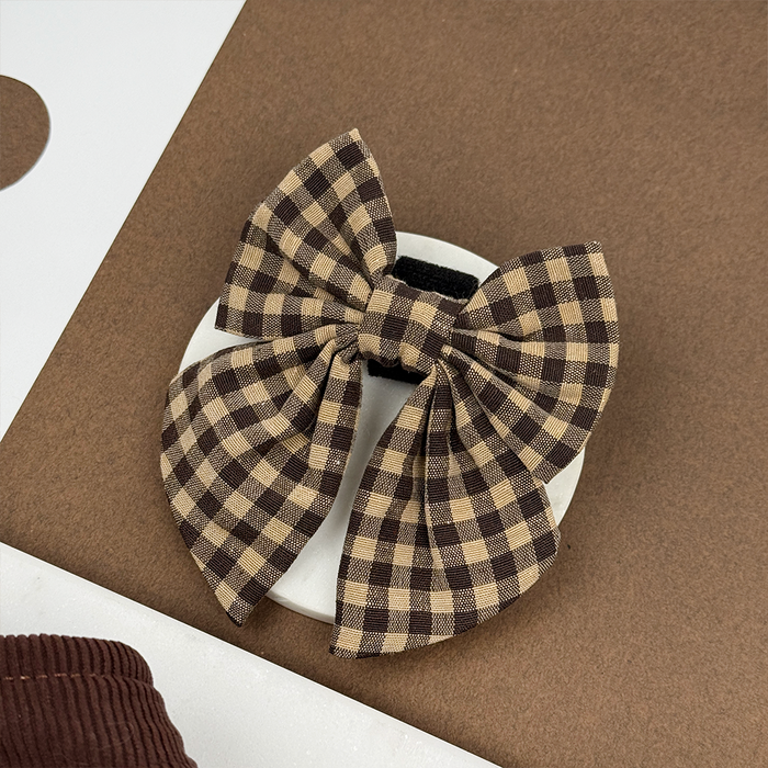 Cotswold Check Sailor Bow Tie hair clip in brown and white plaid, displayed on a white dish with a brown and white background.