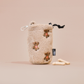 Beige Cocopup London drawstring treat pouch with embroidered teddy and black clip, beside three bone-shaped treats.