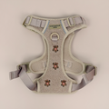Light beige pet harness with pink bear embroidery and adjustable straps.