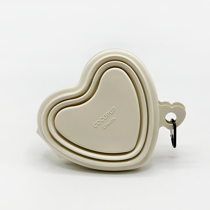 Cream collapsible heart-shaped bowl with a travel clip, branded Cocopup London.