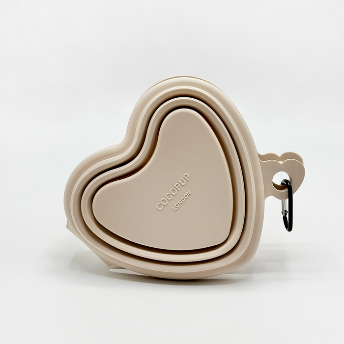 Set of three pink, heart-shaped collapsible dog bowls with metal carabiners attached.