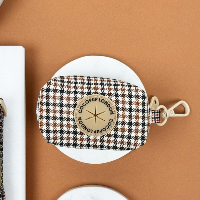 Cocopup London poop bag holder with a heritage check pattern and visible logo, designed for dog walks.