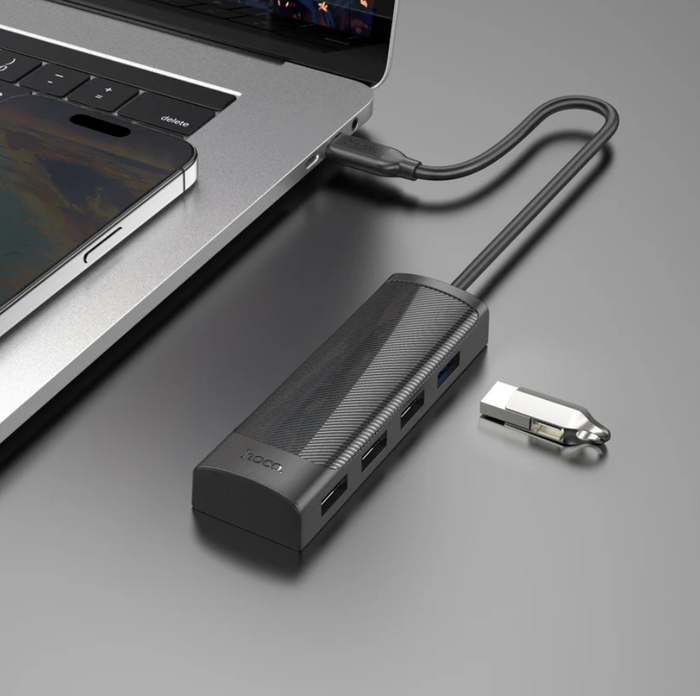 Techplus Hoco USB-C to USB-A 4-in-1 expansion hub with 5Gbps transfer speeds, shown plugged into a laptop.