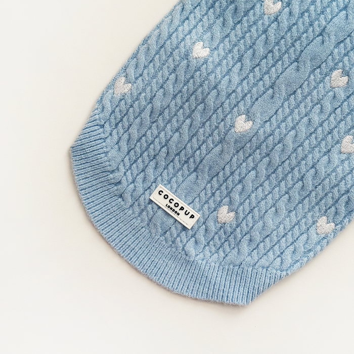 Light blue cable knit jumper with white heart pattern and Cocopup label at the hem.
