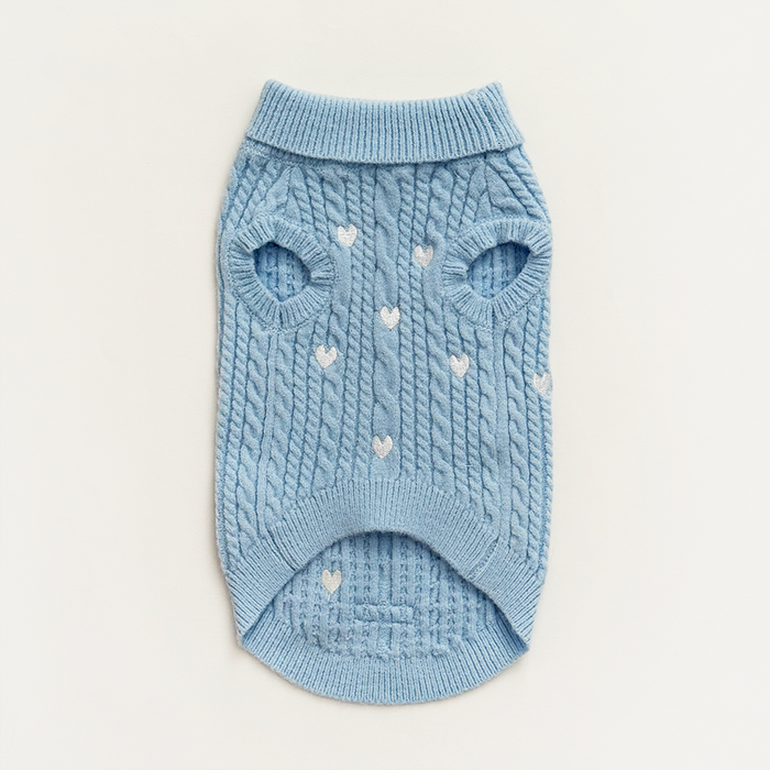 Light blue cable knit dog jumper with white heart pattern, laid flat on a white background.