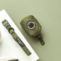 Khaki quilted poop bag holder with zipper and clip, featuring Cocopup London branding.