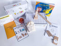 Kids' construction-themed play kit with homemade non-toxic playdough, brick playdough roller, and building blocks. Includes construction plans for educational play, role play items like blueprint and caution tape, blueprint journal with colored pencils and ruler, and 'Jack the Builder' book. Comes with STEAM & Recipe Card and digital plans for interactive learning.