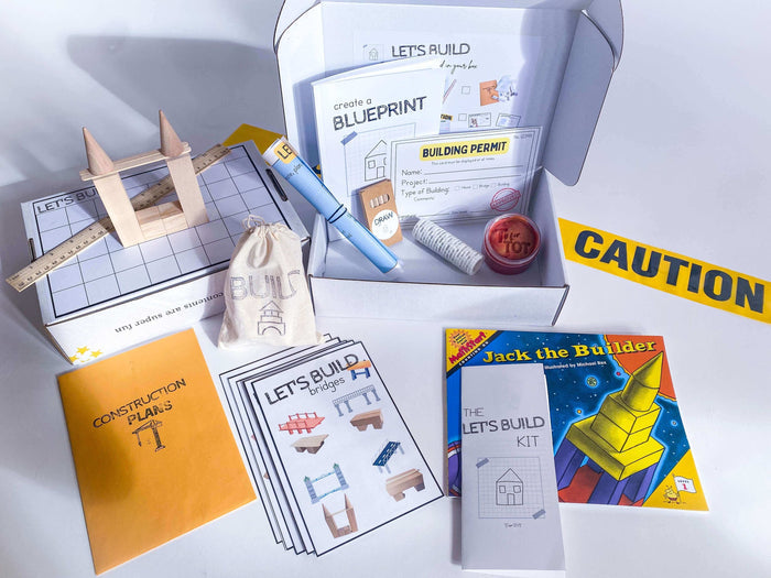 Construction kit for children with homemade playdough, brick playdough roller, building blocks, and construction plans. Features role play items like blueprint, caution tape, and building permit, along with a blueprint journal and 'Jack the Builder' book.