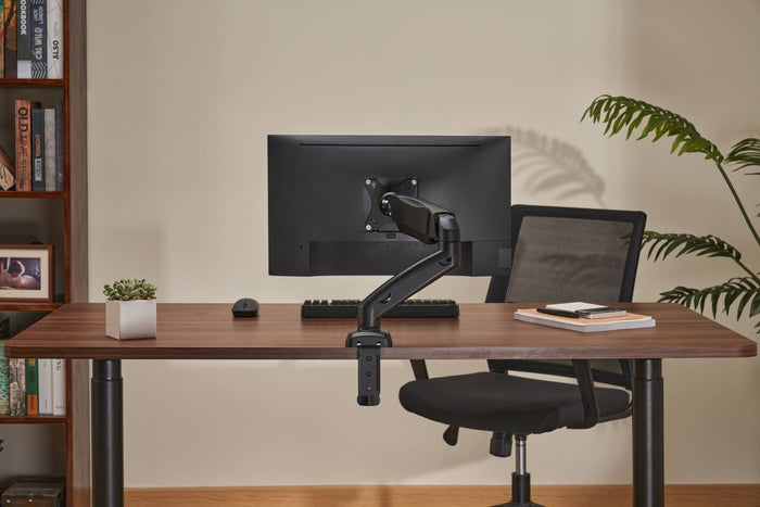 Locktight spring-assisted monitor mount arm by sue-e furniture attached to a desk with a monitor installed, showcasing adjustable monitor accessories.