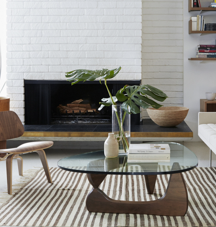 Replica Noguchi coffee table by Sue-E Furniture featuring a sculptural wooden base and round glass top.