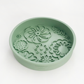 Sage green silicone dog bowl with flower-shaped slow feeder sections.
