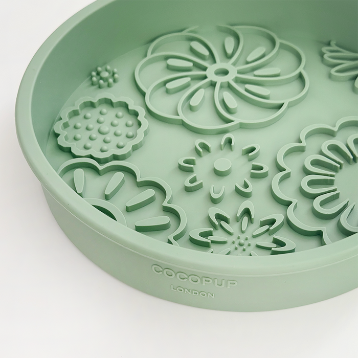 Light green silicone slow feeder dog bowl with raised flower shapes.