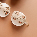 Two cream teddy fleece poop bag holders with embroidered paw prints from Cocopup London.