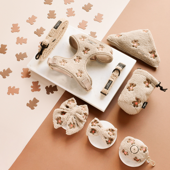 Beige dog accessories with teddy bear cutouts and an embroidered Cocopup London Theo Teddy sailor bow tie.