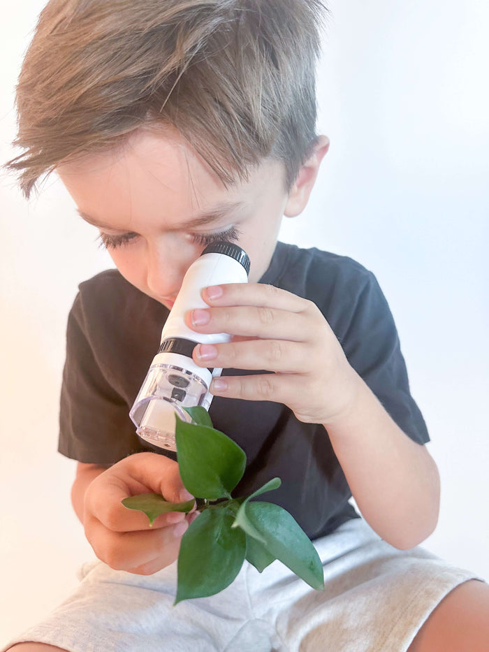 Preschooler looking through a kid-friendly microscope to explore tiny objects