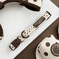 Dog collar with polka dot pattern and visible brand name on a white surface.