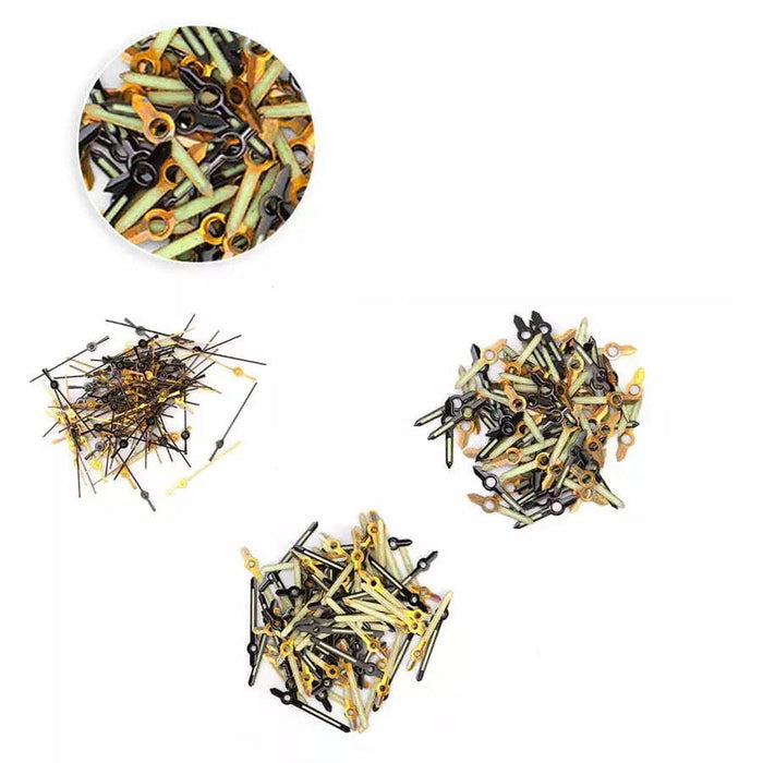 Assorted white watch hour, minute, and second hands with screws, used as watch tools for repairs and assembly.