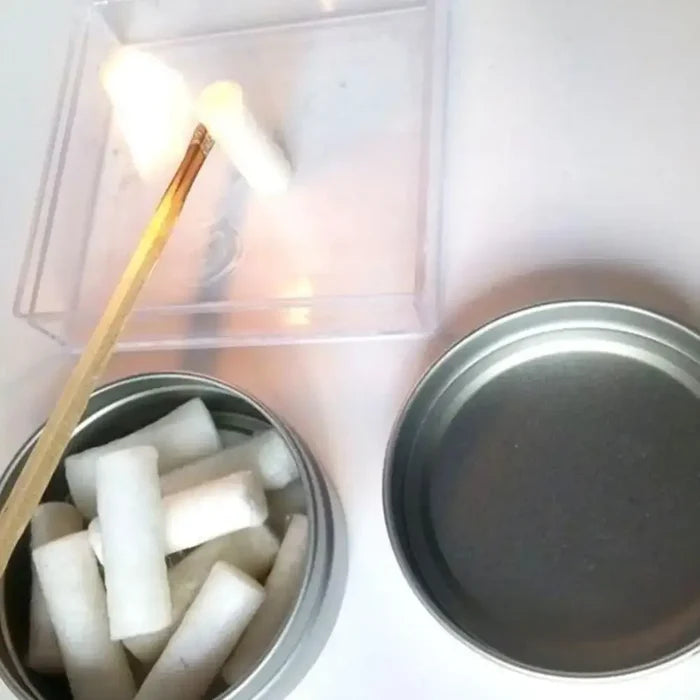 Habicare SS wax braided paraffin swabs used outdoors for fire starting and survival camping, shown as a fire-starting tool.