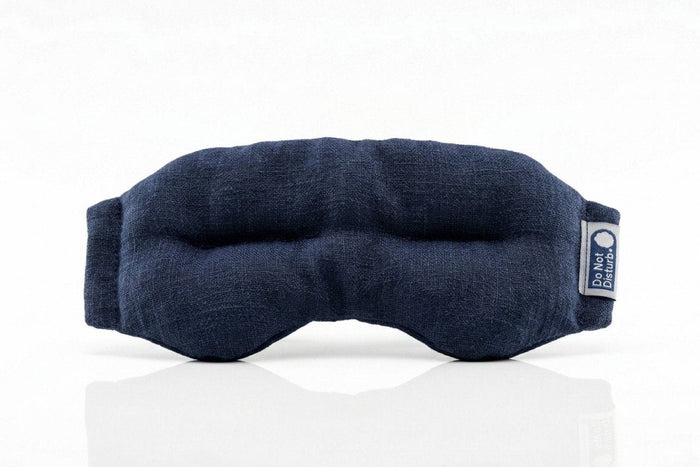 Midnight blue Do Not Disturb Sleep Company weighted eye mask with soft fabric and adjustable strap for relaxation and sleep.